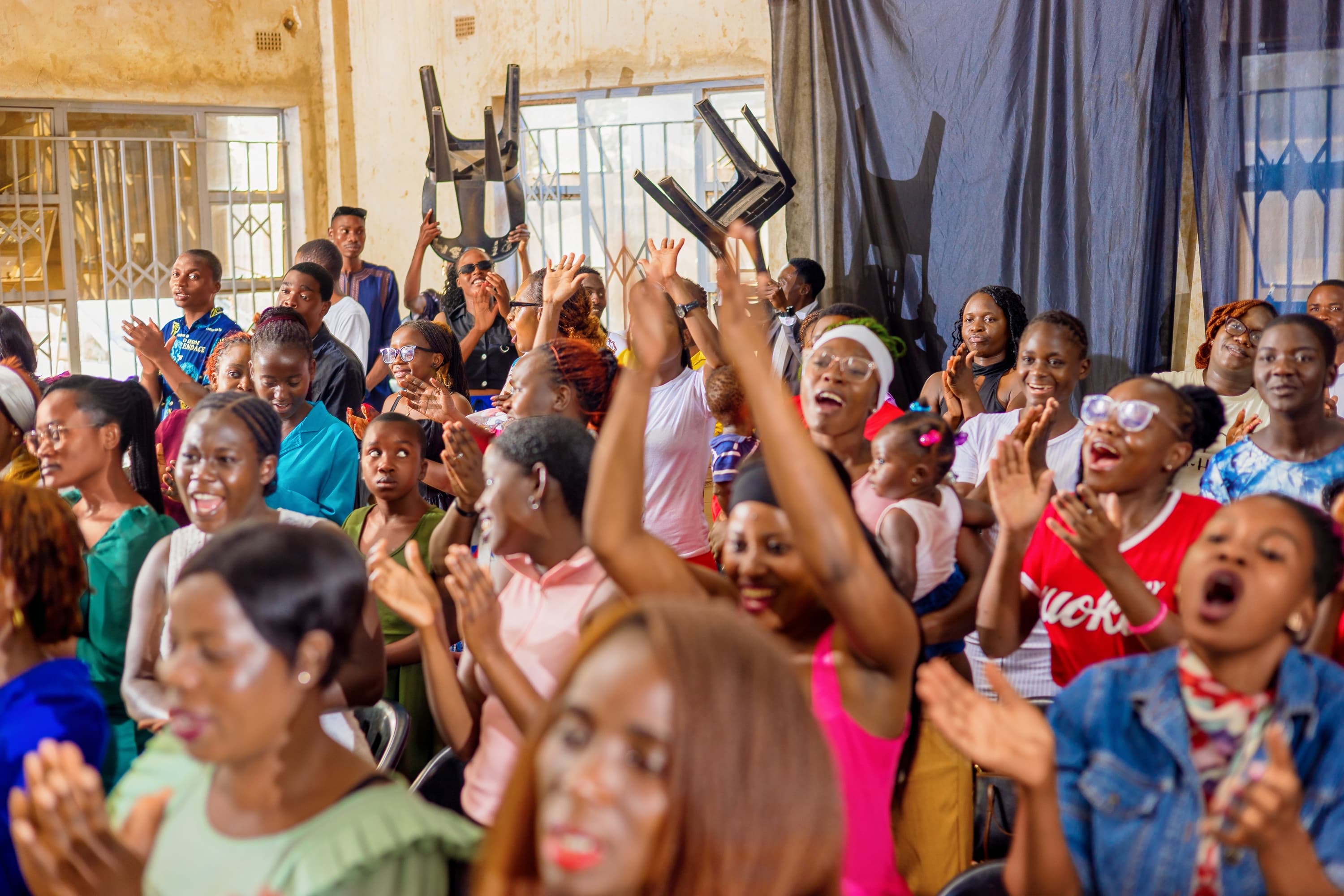 Members of the Solution Centre congregation clapping and raising their hands
